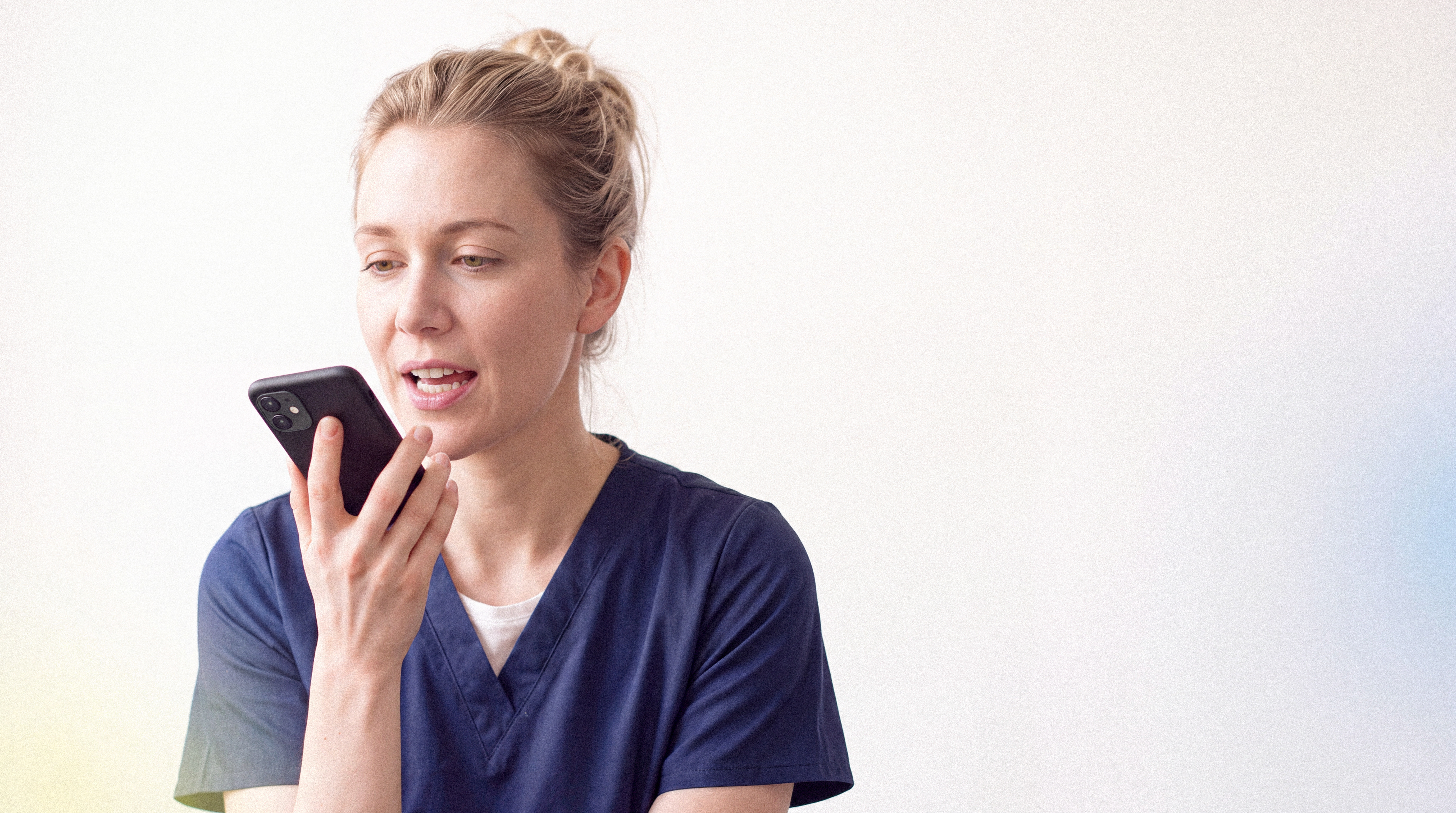 Pflegefachperson spricht in ein Smartphone.